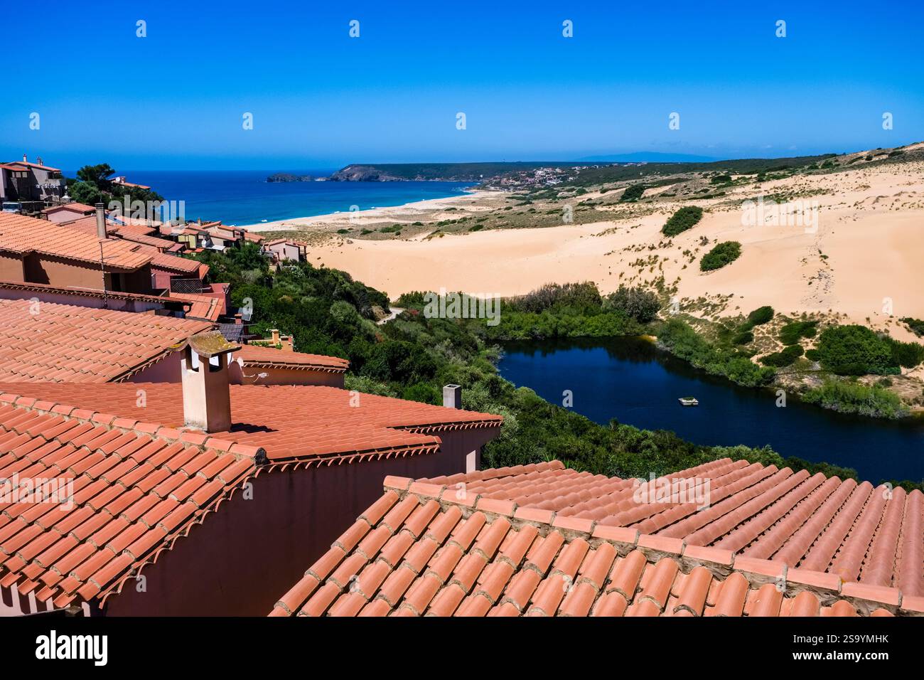 Vue aérienne sur les toits des maisons dans le petit village de Torre dei Corsari sur la plage Arenas S'Acqua e S'Ollastu et de grandes dunes de sable. Banque D'Images