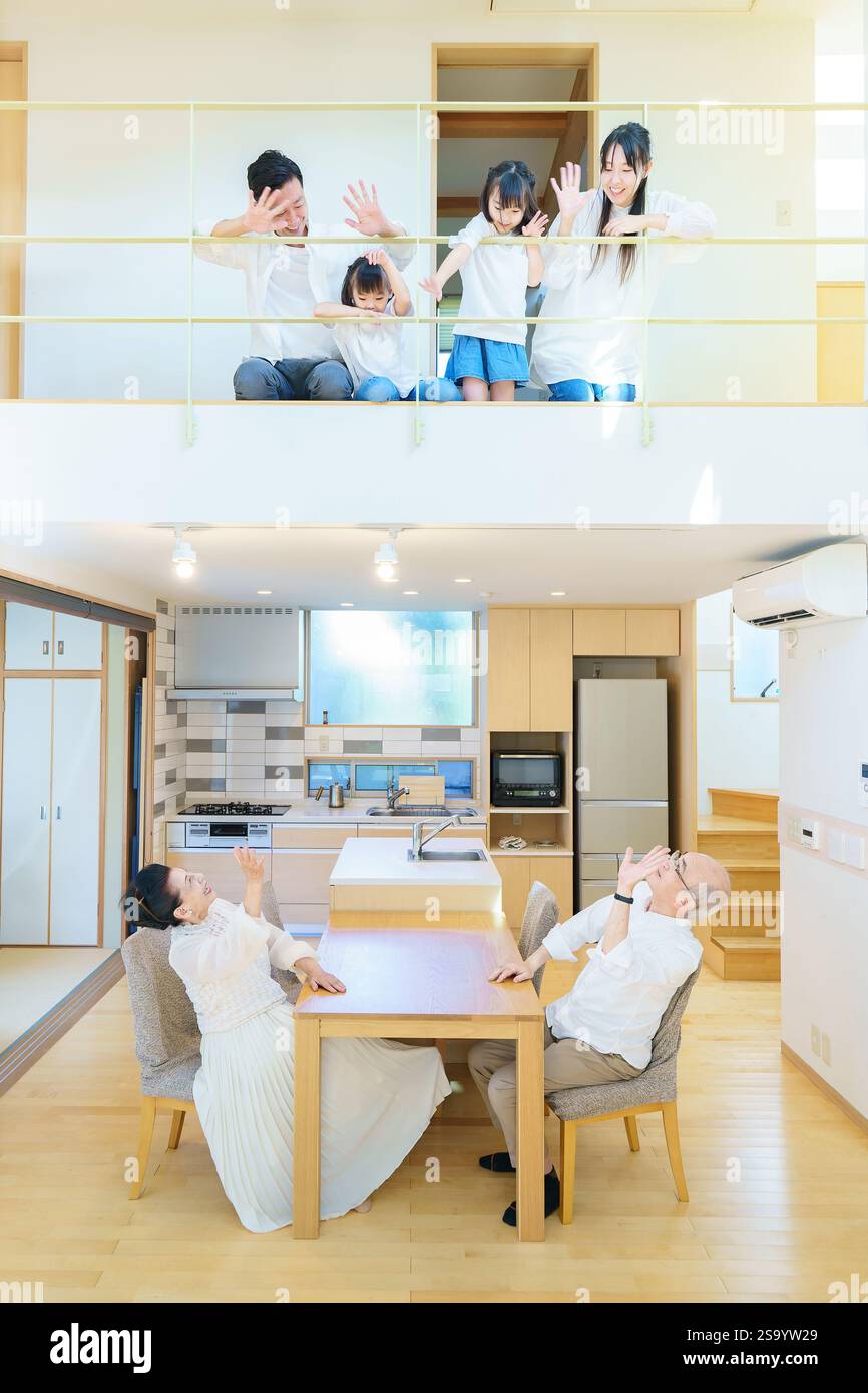 Famille de trois générations alignée au premier et deuxième étage d'une maison Banque D'Images