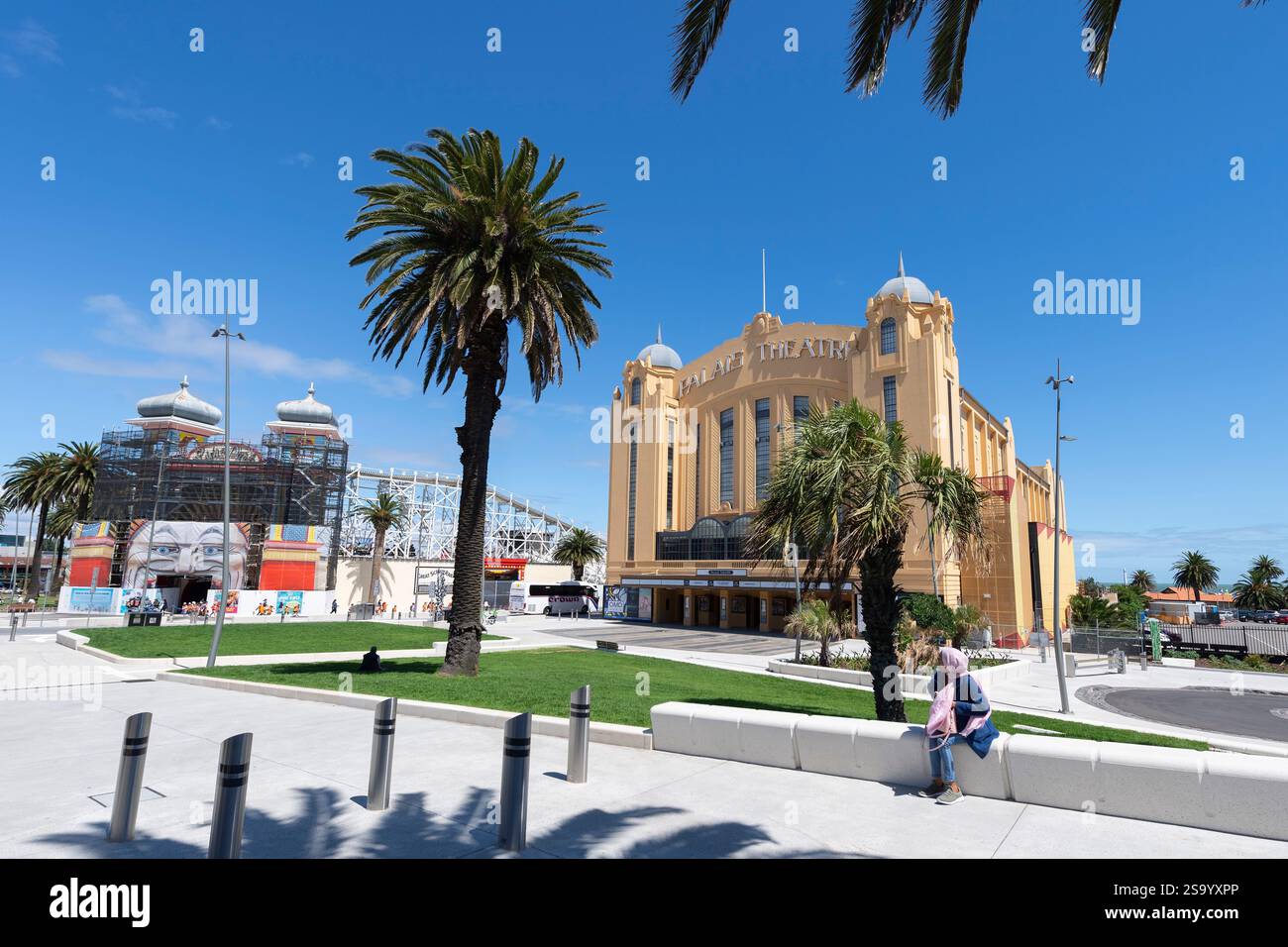 Arab Girl est assis devant l'architecture ornée du Palais Theatre des années 1920, un palais historique de tableau par un jour de ciel bleu ensoleillé St Kilda, Melbourne Banque D'Images