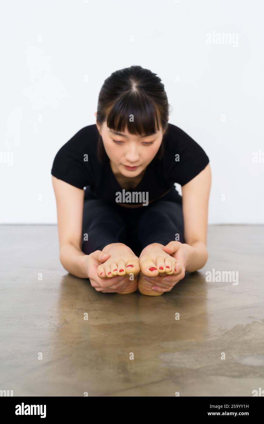 Femme faisant un exercice de flexion avant Banque D'Images