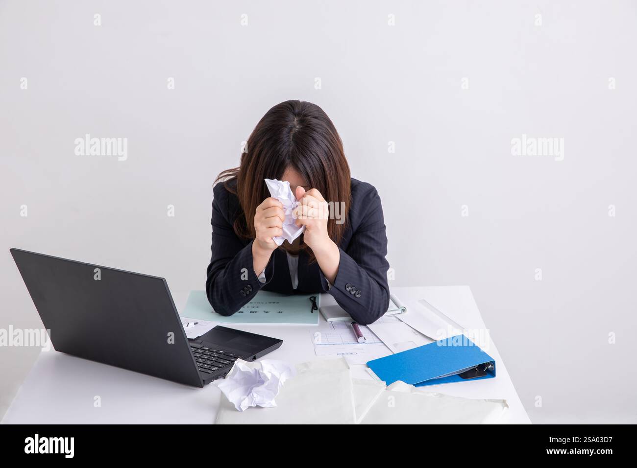Femme se sentant stressée à cause du travail empilé Banque D'Images