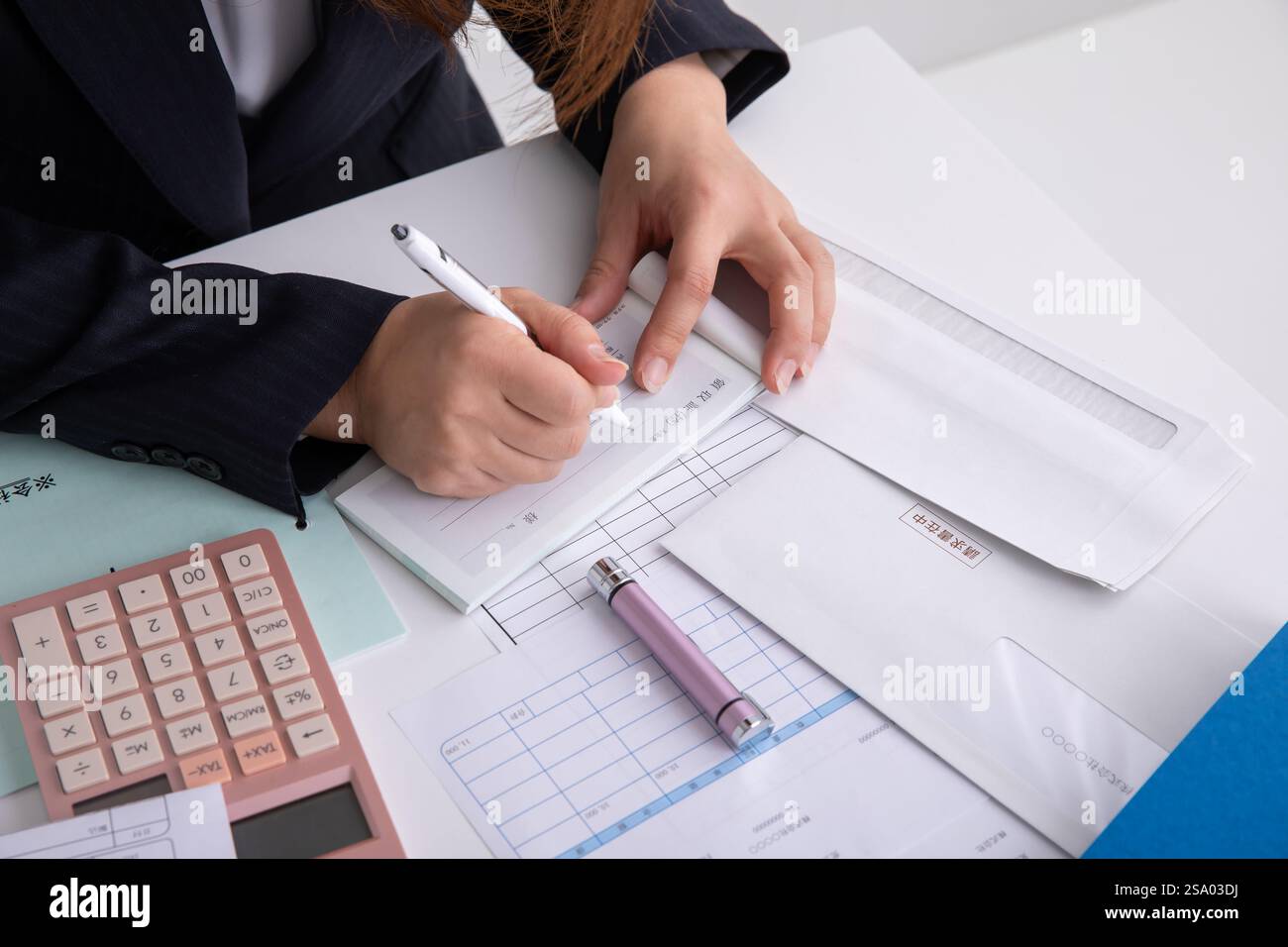 Femme en costume écrivant un reçu Banque D'Images