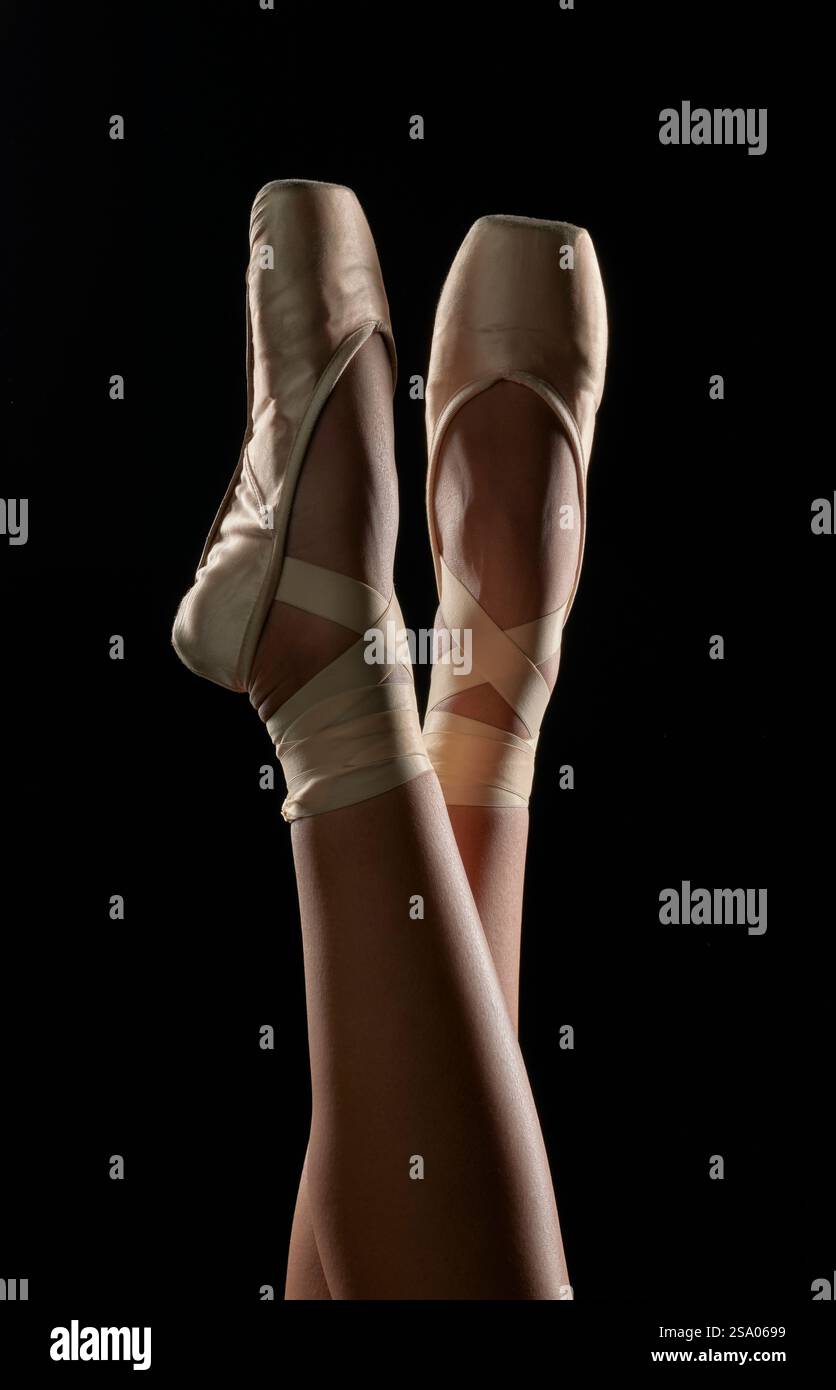 Ballet Dancer’s Legs dans pointe Shoes sur fond Black Studio Banque D'Images