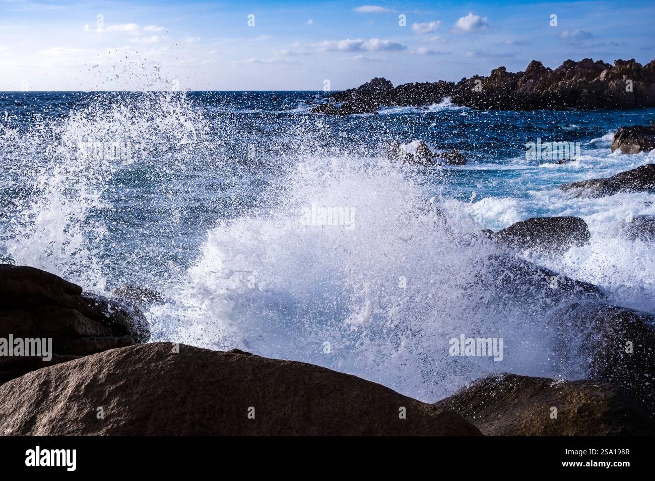 De l'eau de mer éclabousse sur la côte déchiquetée avec des rochers de granit près de la petite ville côtière de Costa Paradiso. Banque D'Images