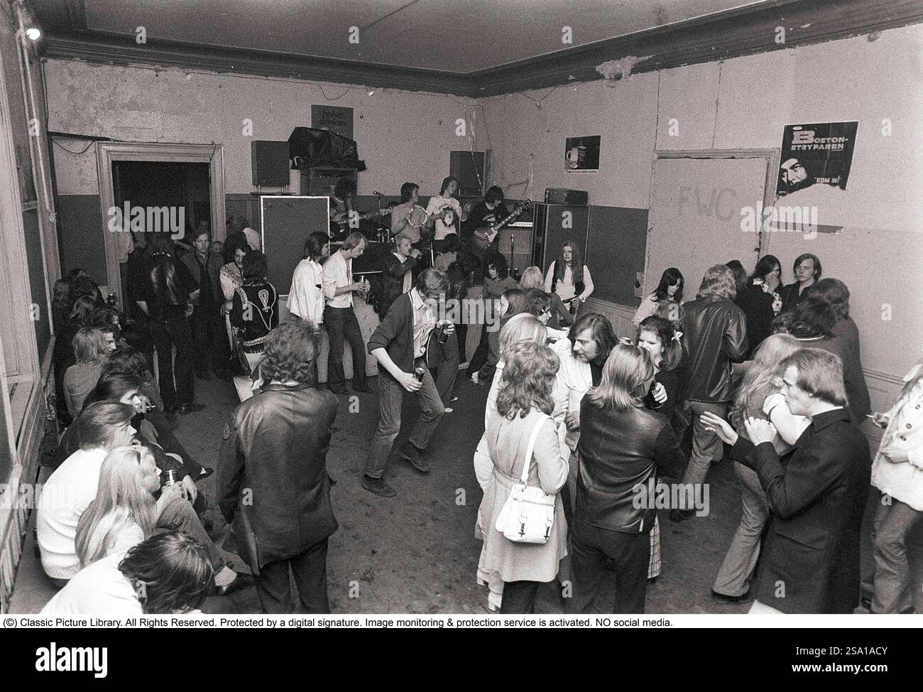 C'est ainsi que les gens faisaient la fête dans les années 1970 Les gens dansent et boivent de la bière pendant qu'un groupe joue de la musique live. Les femmes et les hommes dansent au son de la musique, boivent de la bière et fument dans une salle de fête plutôt terne que tout le monde semble apprécier et s'amuser. 1970. Kristoffersson ref 4-106-107 Banque D'Images