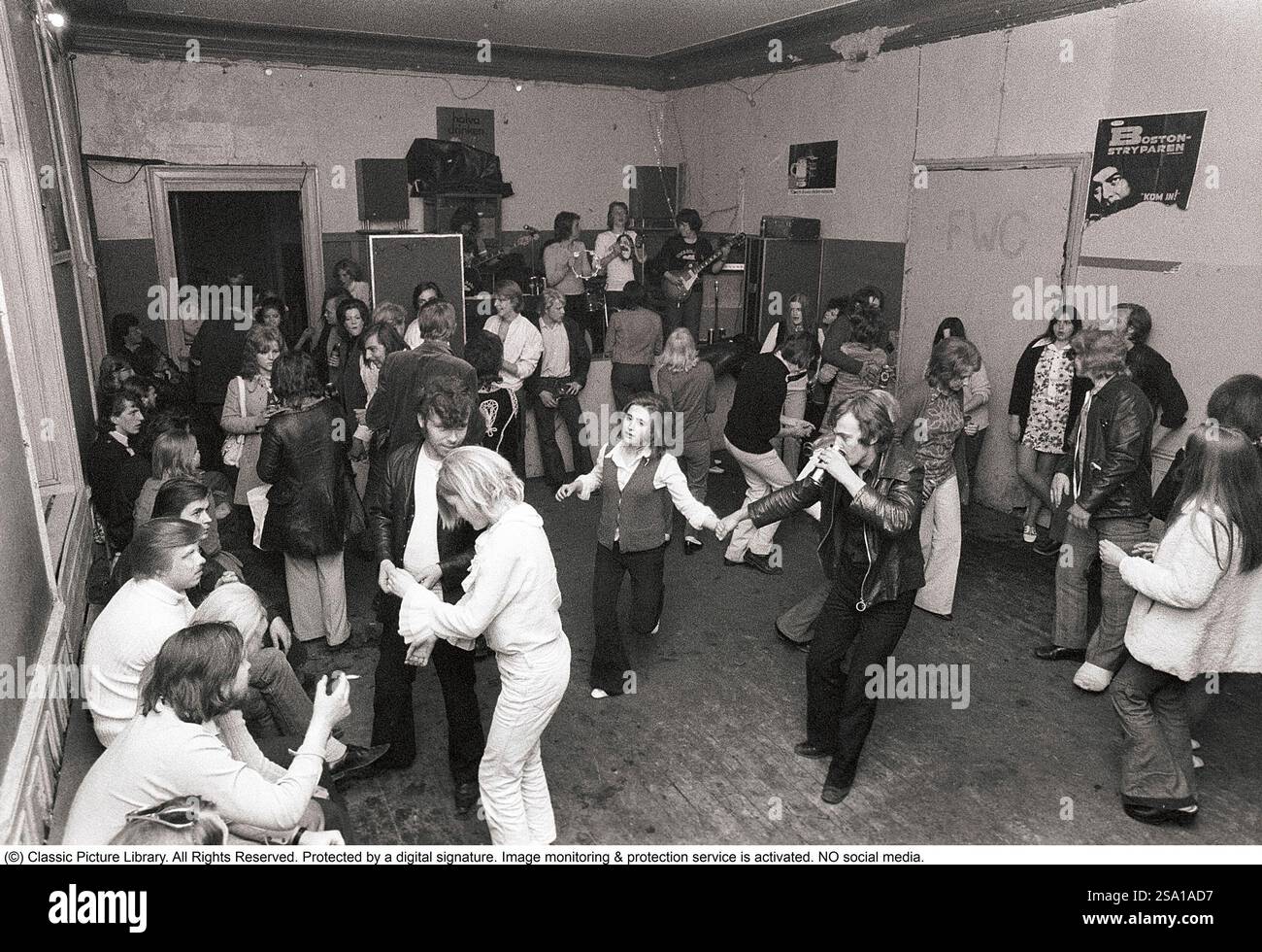 C'est ainsi que les gens faisaient la fête dans les années 1970 Les gens dansent et boivent de la bière pendant qu'un groupe joue de la musique live. Les femmes et les hommes dansent au son de la musique, boivent de la bière et fument dans une salle de fête plutôt terne que tout le monde semble apprécier et s'amuser. 1970. Kristoffersson ref 4-106-107 Banque D'Images