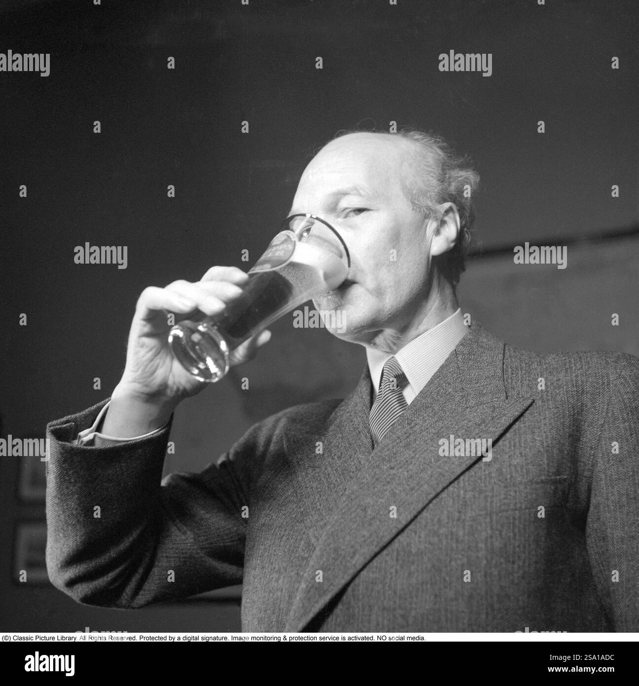 Erik Olson (1886-1966) industriel suédois. Chef de la brasserie Pripp & Lyckholm à Gothenburg. On le voit boire dans un verre à bière, la bière de sa propre entreprise de production. 1943. Kristoffersson ref E133-4 Banque D'Images