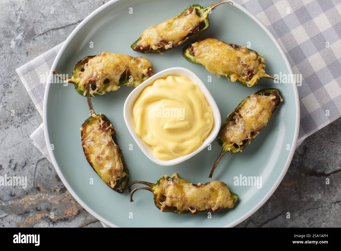 Popers jalapeno chauds avec fromage et bœuf haché en gros plan sur l'assiette sur la table. Vue horizontale de dessus Banque D'Images