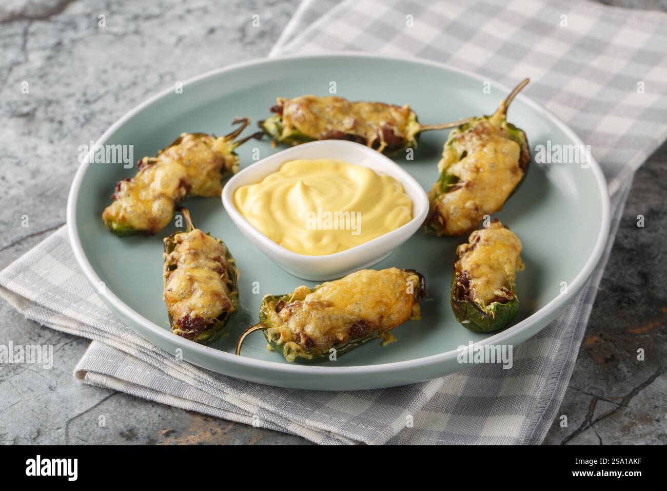 Popers jalapeno chauds avec fromage et bœuf haché en gros plan sur l'assiette sur la table. Horizontal Banque D'Images