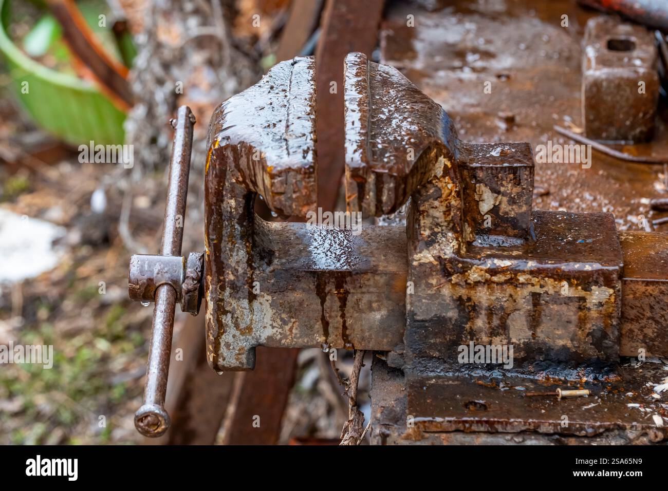Un outil en métal rouillé avec une poignée et une pièce métallique qui ressemble à un tournevis. La poignée est rouillée et le tournevis est manquant Banque D'Images
