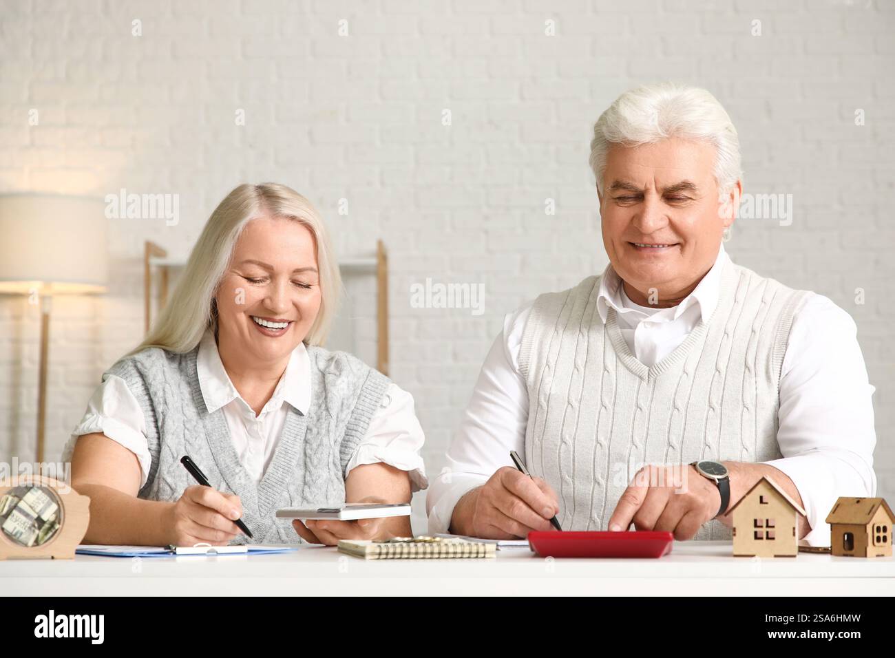 Couple aîné calculant les factures de services publics sur table à la maison Banque D'Images