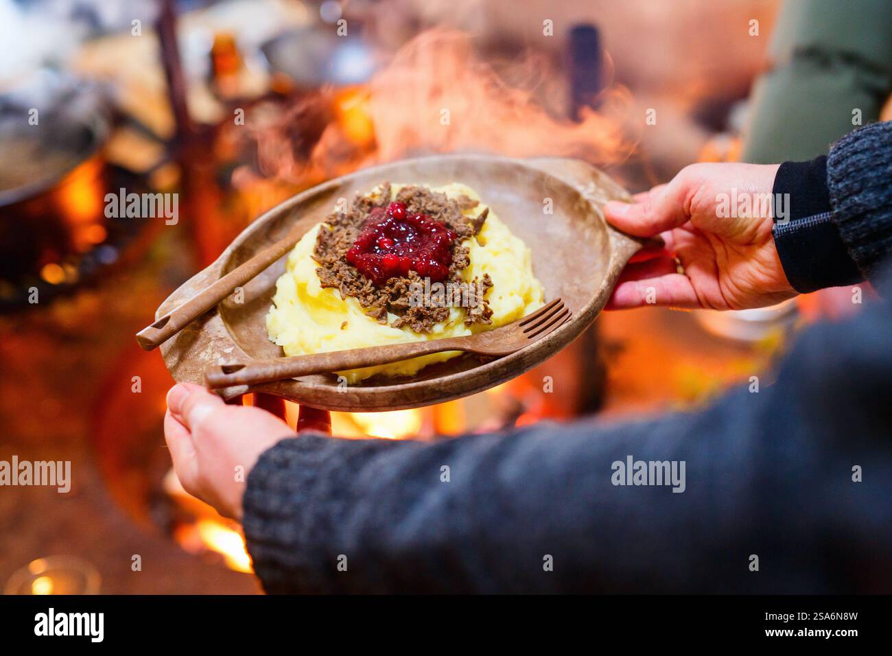 Rennes sautés avec purée de pommes de terre et airelles servis dans une cabane lappish à côté d'un feu ouvert Banque D'Images