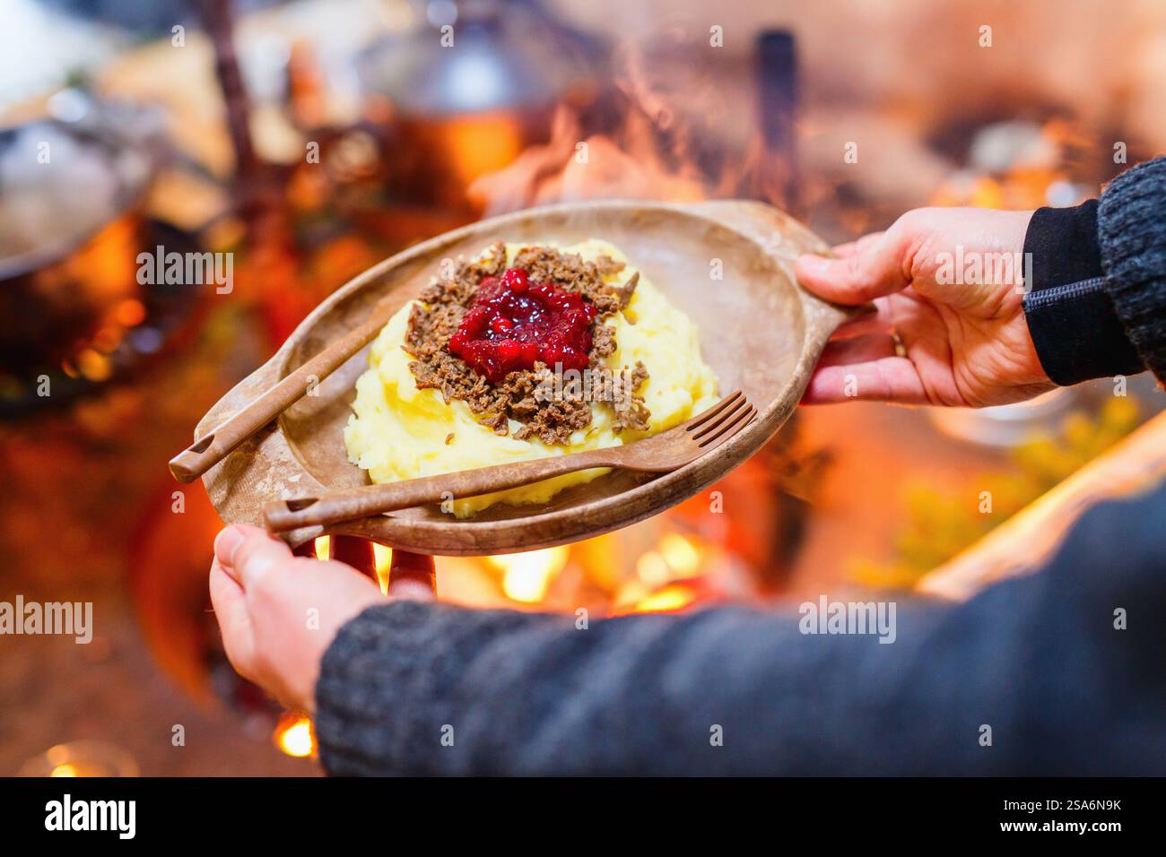 Rennes sautés avec purée de pommes de terre et airelles servis dans une cabane lappish à côté d'un feu ouvert Banque D'Images