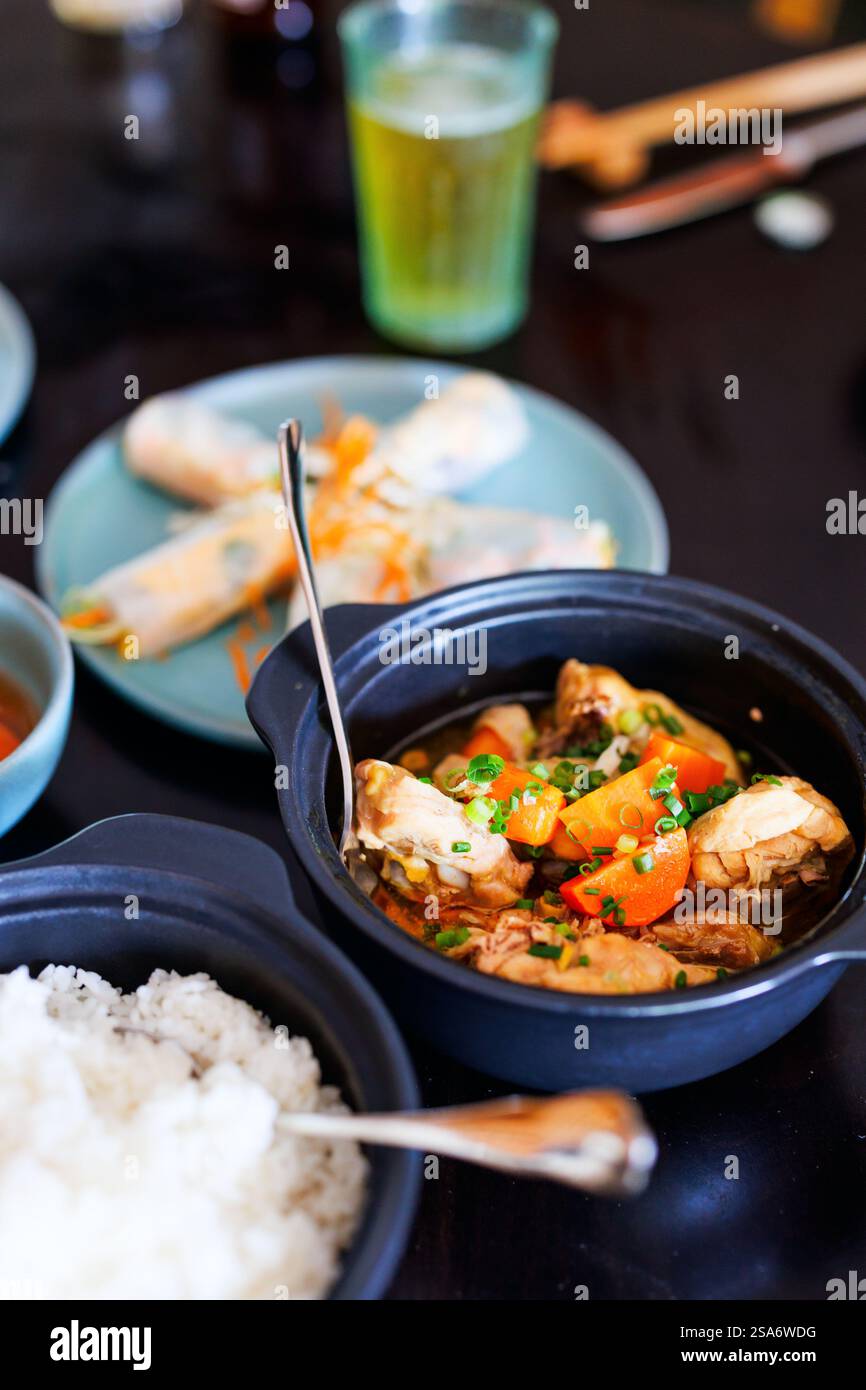 Délicieux déjeuner de poulet, riz, légumes et rouleaux de printemps servis au restaurant Banque D'Images
