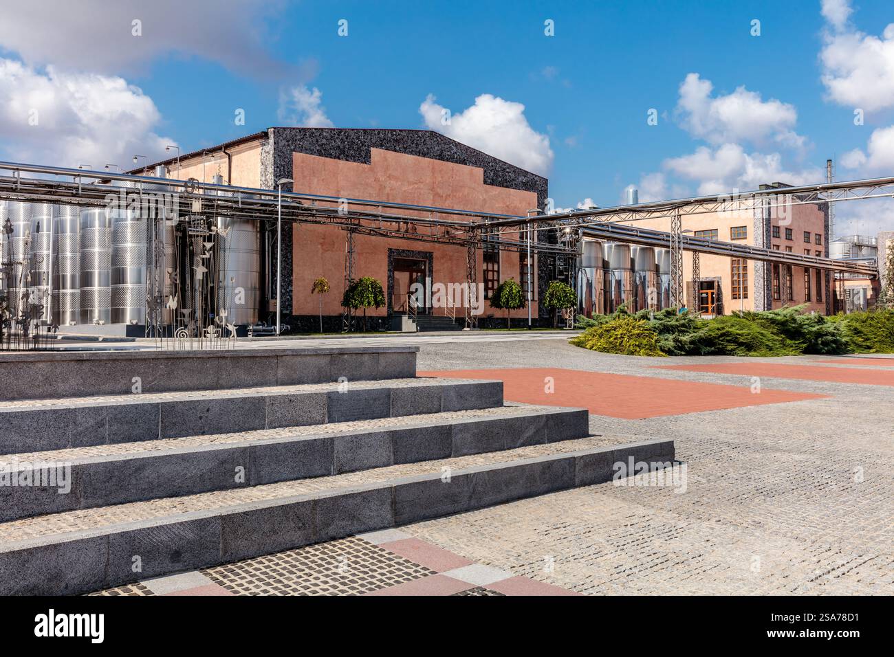 Un bâtiment avec un grand toit et un escalier qui y mène. Le bâtiment est entouré d'une passerelle en briques Banque D'Images