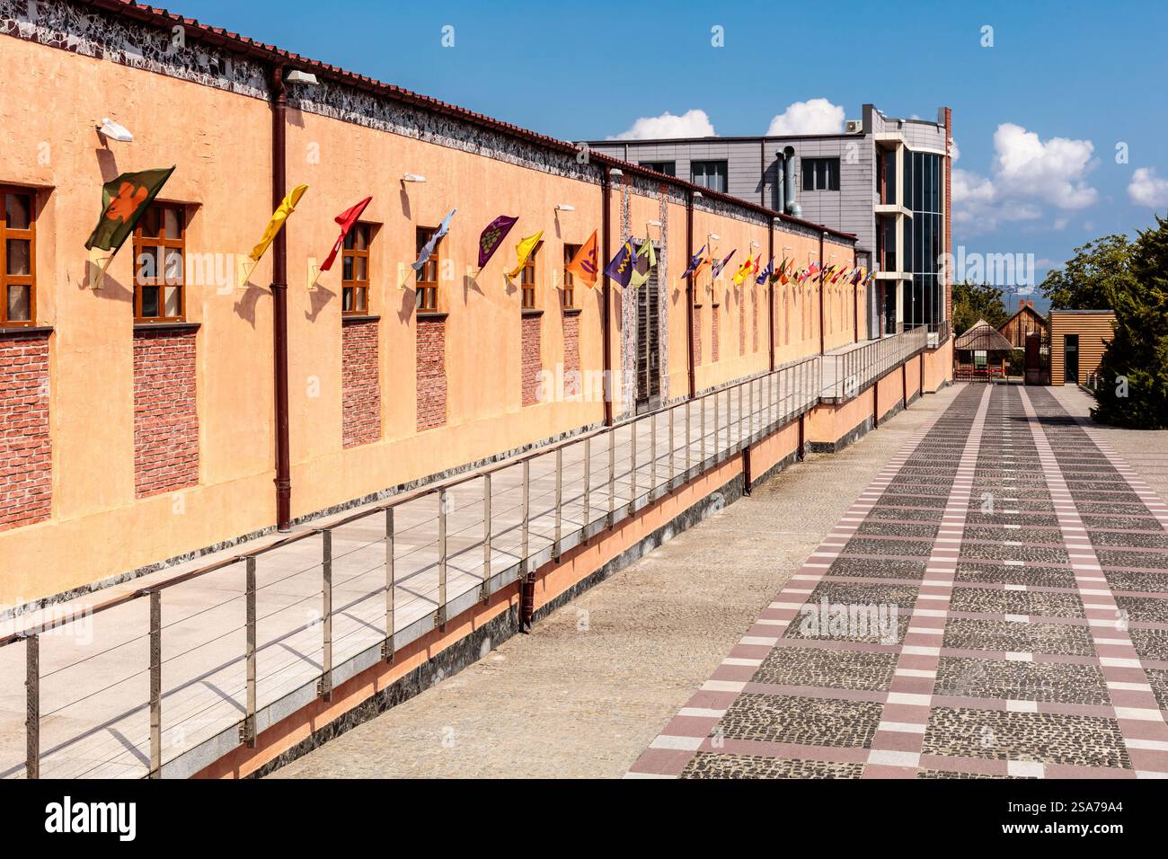 Un long bâtiment avec de nombreuses fenêtres et drapeaux suspendus au toit. Les drapeaux sont de différentes couleurs et tailles Banque D'Images