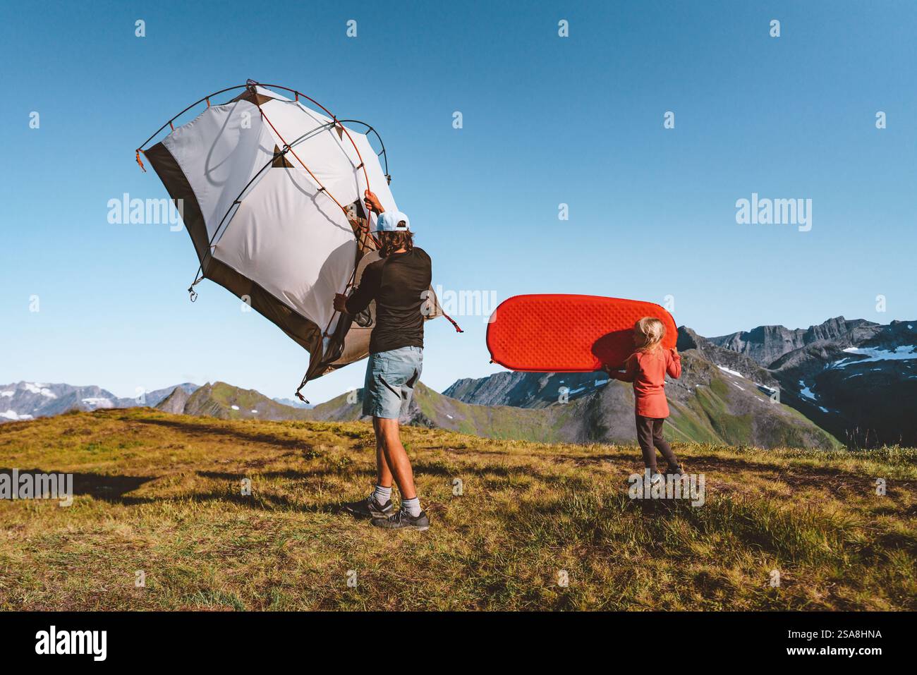 Famille voyageant avec du matériel de camping dans les montagnes père et enfant randonnée portant tente et matelas de couchage - vacances de voyage actif en plein air ensemble adve Banque D'Images Famille voyageant avec du matériel de camping dans les montagnes père et enfant randonnée portant tente et matelas de couchage - vacances de voyage actif en plein air ensemble adve Banque D'Images