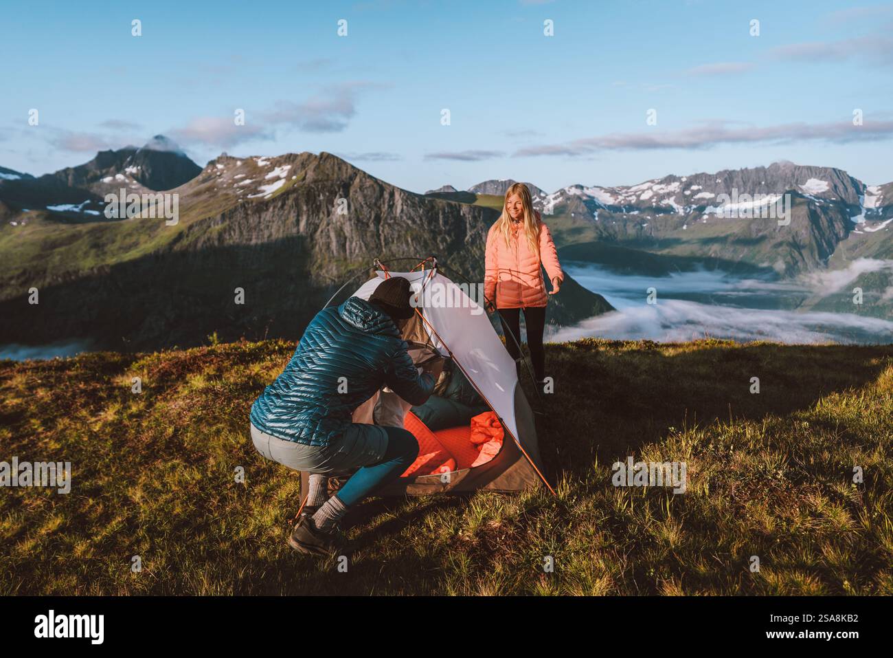 Couple homme et femme installant leur équipement de tente de camping dans les montagnes, amis voyageant en plein air vacances actives randonnées aventures famille utilisant Climbi Banque D'Images
