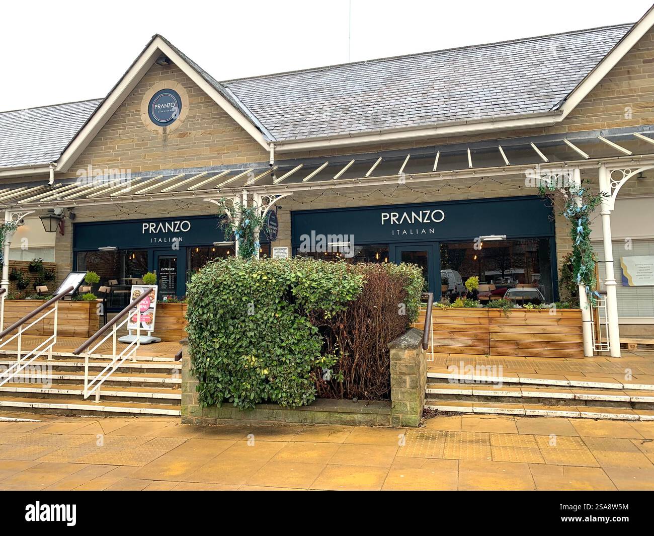 Ilkley Moore Yorkshire Royaume-Uni Grande-Bretagne Angleterre boutique magasins W H Smith Restaurant Pub bar nourriture manger manger à l'extérieur des bâtiments en pierre par temps humide vieux - Image de stock capturée avec un smartphone