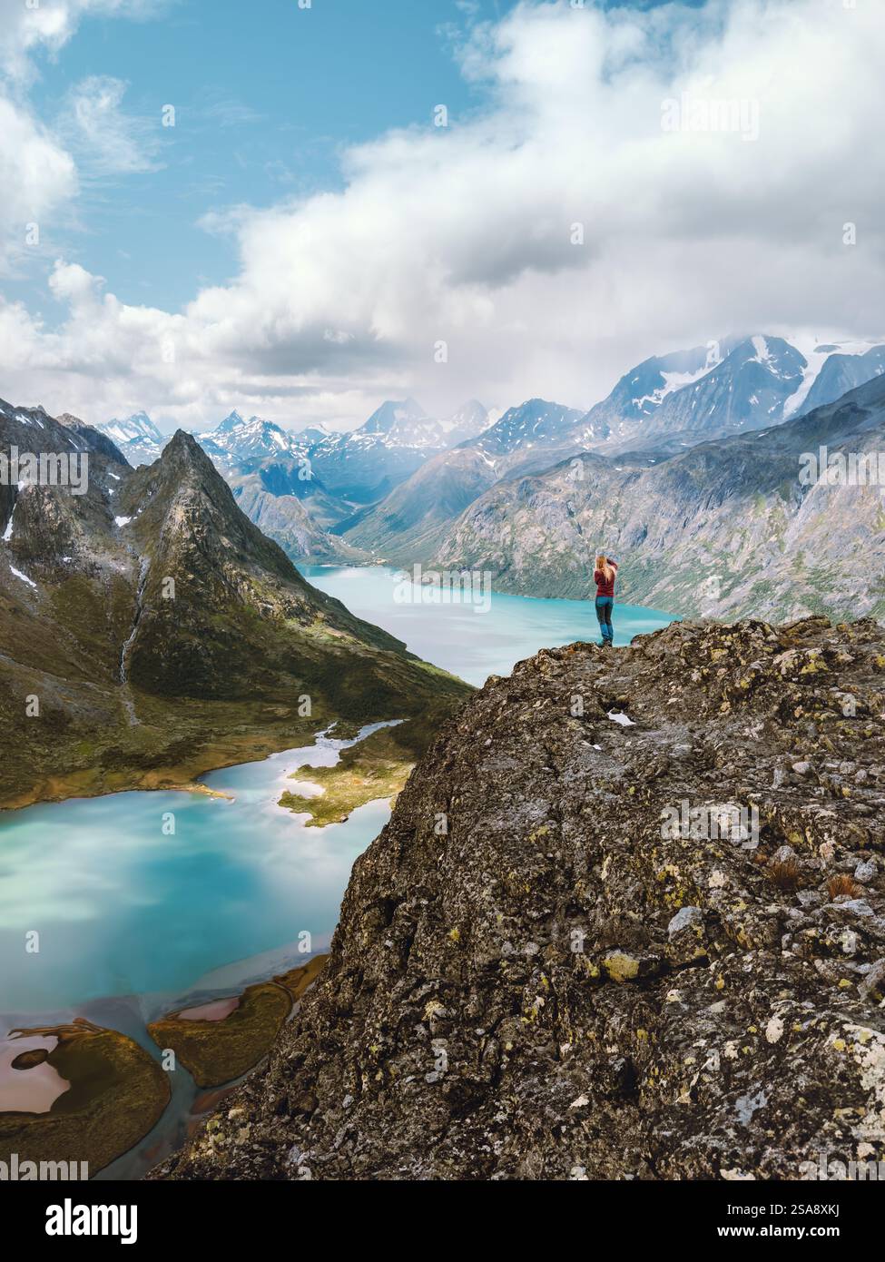 Voyageur randonnée en Norvège voyage en plein air vacances d'été actives, montagnes et paysages de lacs dans le parc Jotunheimen, femme debout sur la falaise seul hea Banque D'Images
