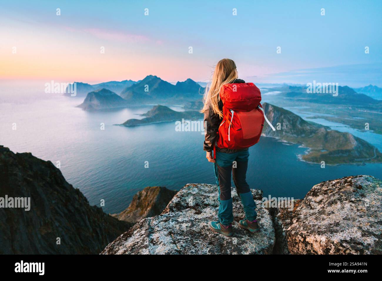 Femme alpinisme avec sac à dos fille solo voyageant dans les îles Lofoten profitant de la vue aérienne touriste randonnée en plein air en Norvège vie saine acti Banque D'Images