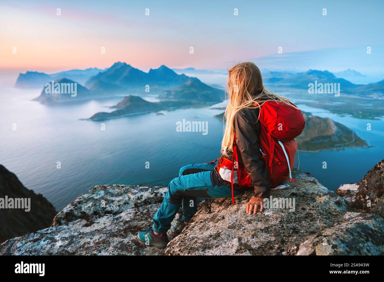 Femme randonneur profitant de la vue aérienne en Norvège fille voyageant avec sac à dos se refroidissant sur le bord de falaise de montagne dans les îles Lofoten touriste randonnée solo en plein air Banque D'Images