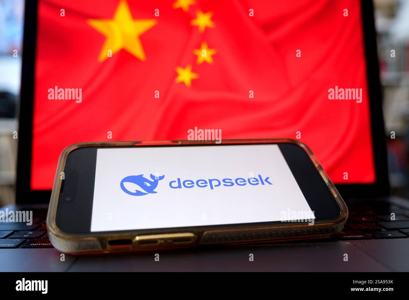 Téléphone portable avec le logo du chatbot chinois IA deepseek devant un ordinateur portable avec le drapeau chinois (photo symbolique) Banque D'Images