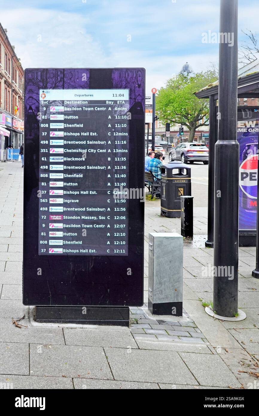 Horaires de bus de départ listés et mis à jour sur le tableau d'affichage fourni par le conseil du comté d'Essex sur le trottoir à côté de l'arrêt de bus animé Brentwood Essex Angleterre Royaume-Uni Banque D'Images