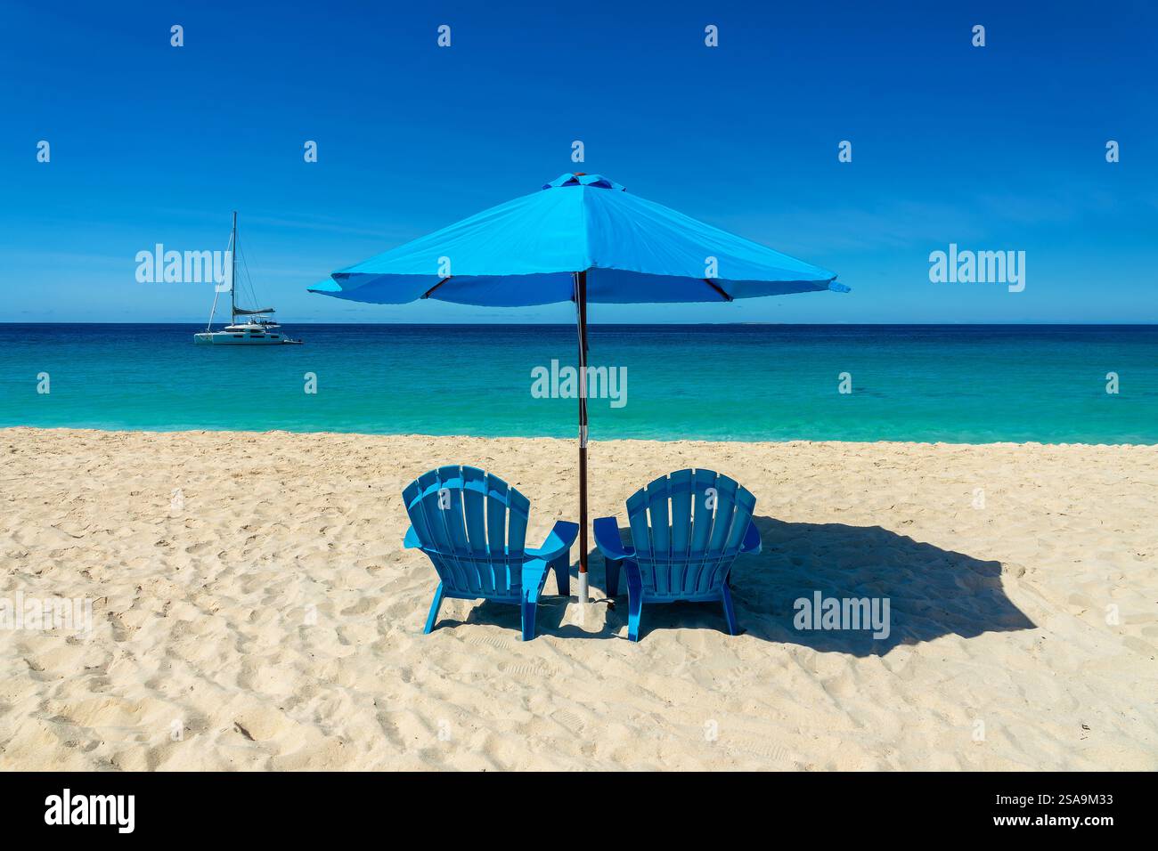 Deux chaises de plage bleues et parasols sur la plage de Meads Bay, rêve et paysage des Caraïbes, île d'Anguilla, Antilles britanniques Banque D'Images