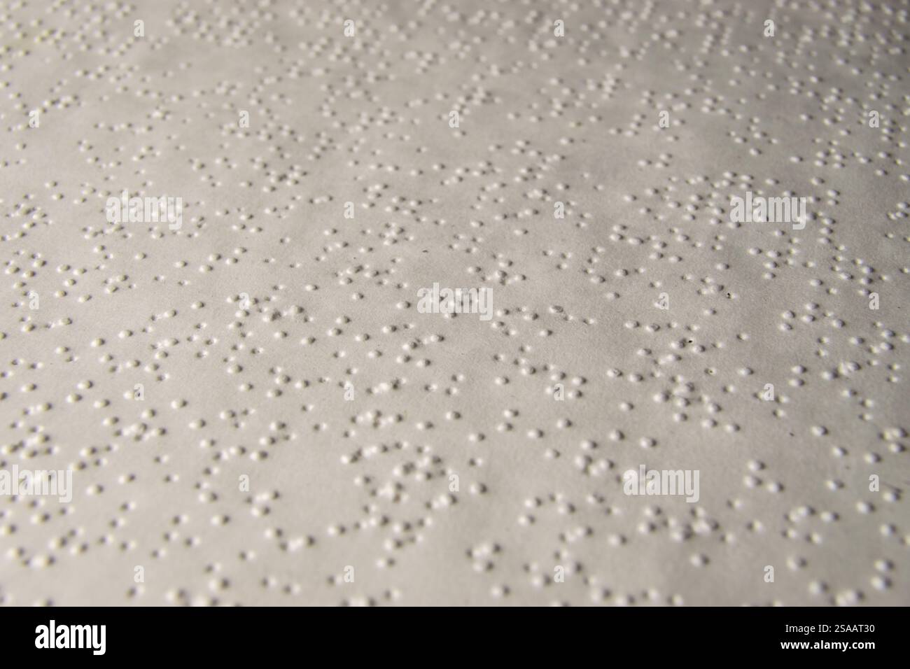 Livre blanc imprimé alphabet braille. Papier imprimé en alphabet braille. Prise de vue macro. Lumineux, faible profondeur de champ. Livre pour aveugles. Banque D'Images
