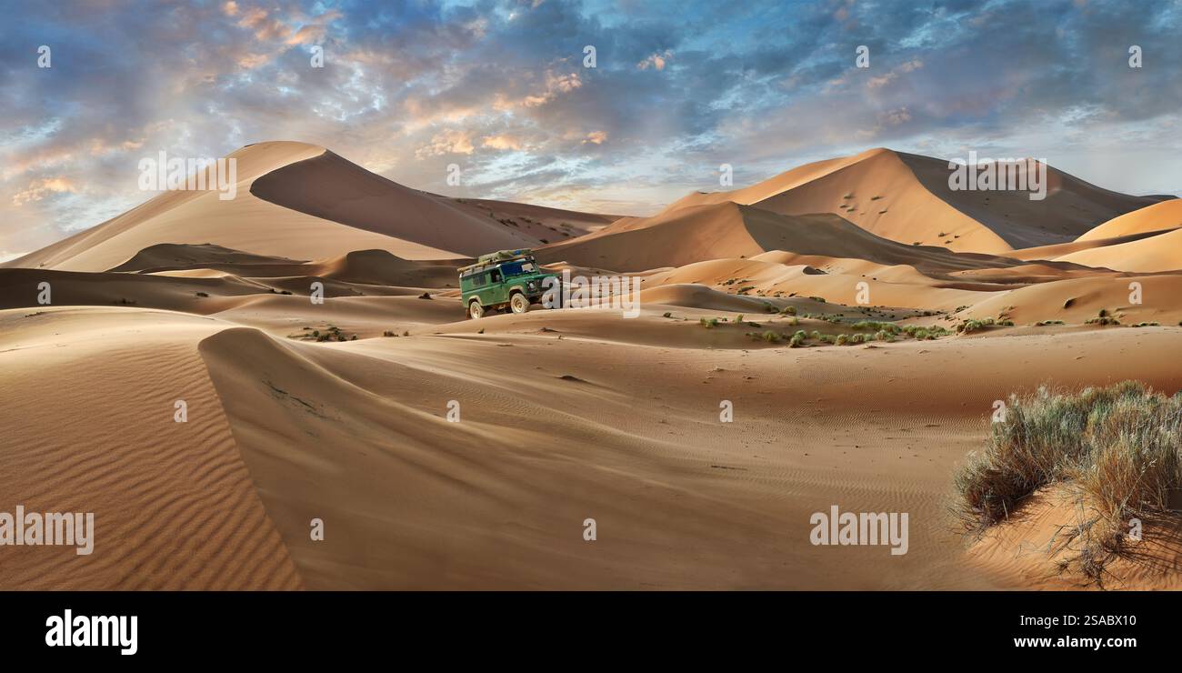 Land Rover Defender 4x4 conduite dans la ceinture de sable de l'Erg Chebbi Sahara, Merzouga Maroc, la ceinture de dunes de sable mesure 5-7 km de large et s'élève à 150 mètres de haut. Banque D'Images
