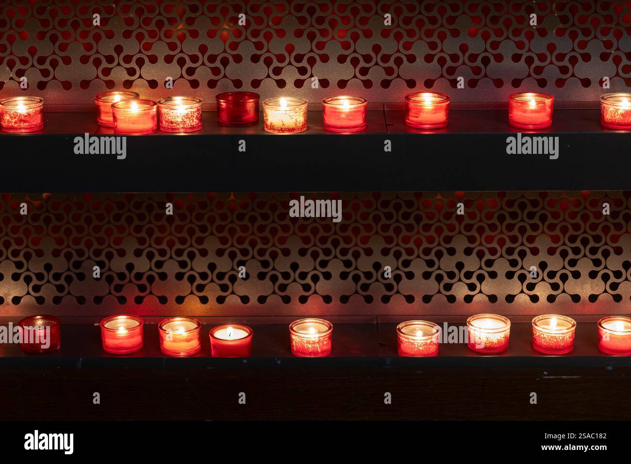 Porte-bougie votive ou de prière allumée dans une église, tradition chrétienne. Banque D'Images