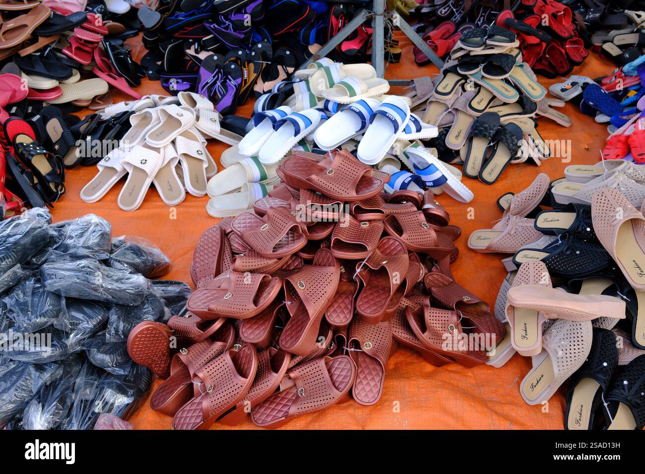 Sandales en plastique colorées fabriquées en Chine pour la vente sur un marché. Tan Chau. Vietnam. Banque D'Images