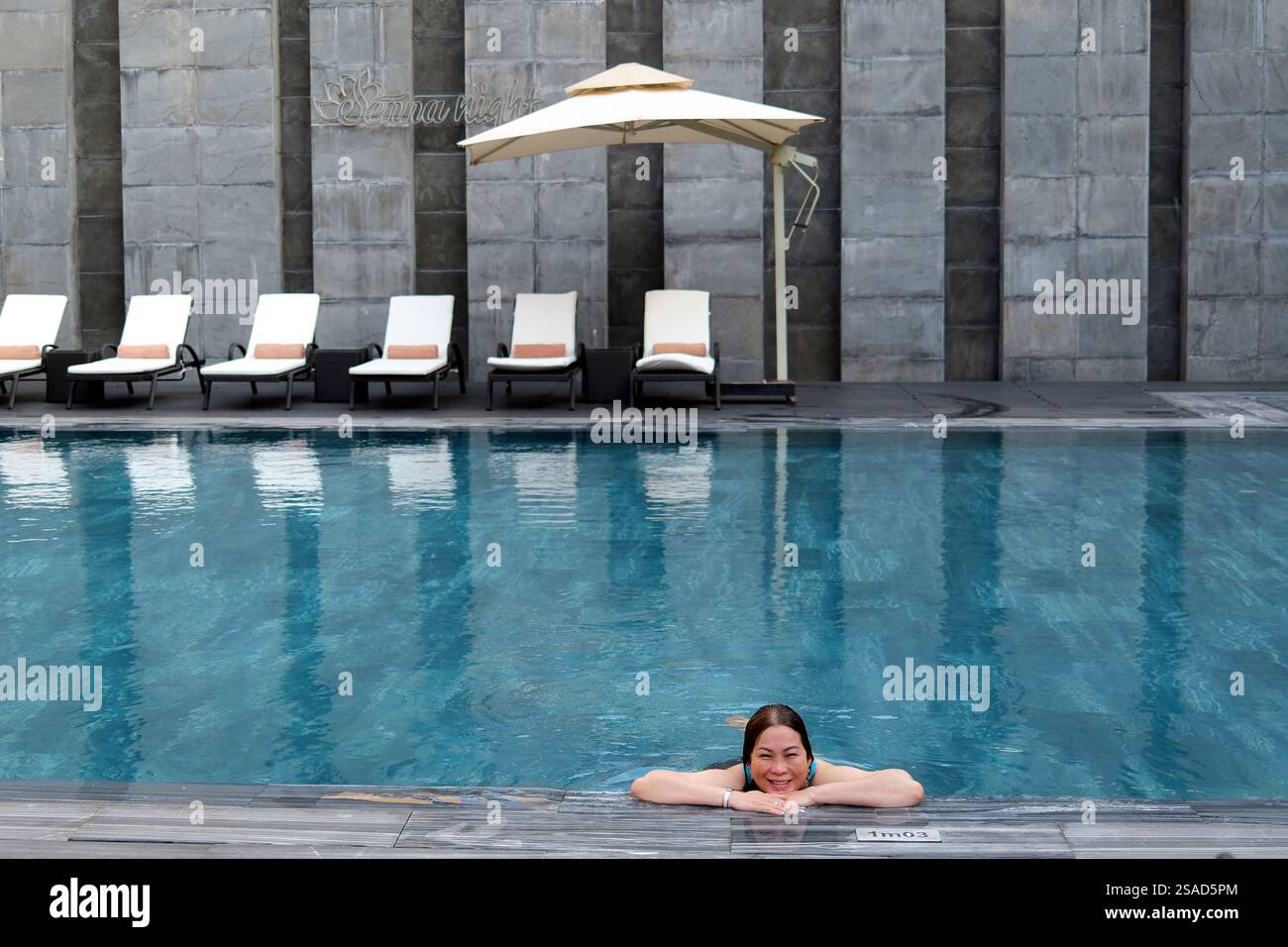 Piscine dans un hôtel de luxe. Femme en vacances profitant de l'eau. Teinte. Vietnam. Banque D'Images Piscine dans un hôtel de luxe. Femme en vacances profitant de l'eau. Teinte. Vietnam. Banque D'Images