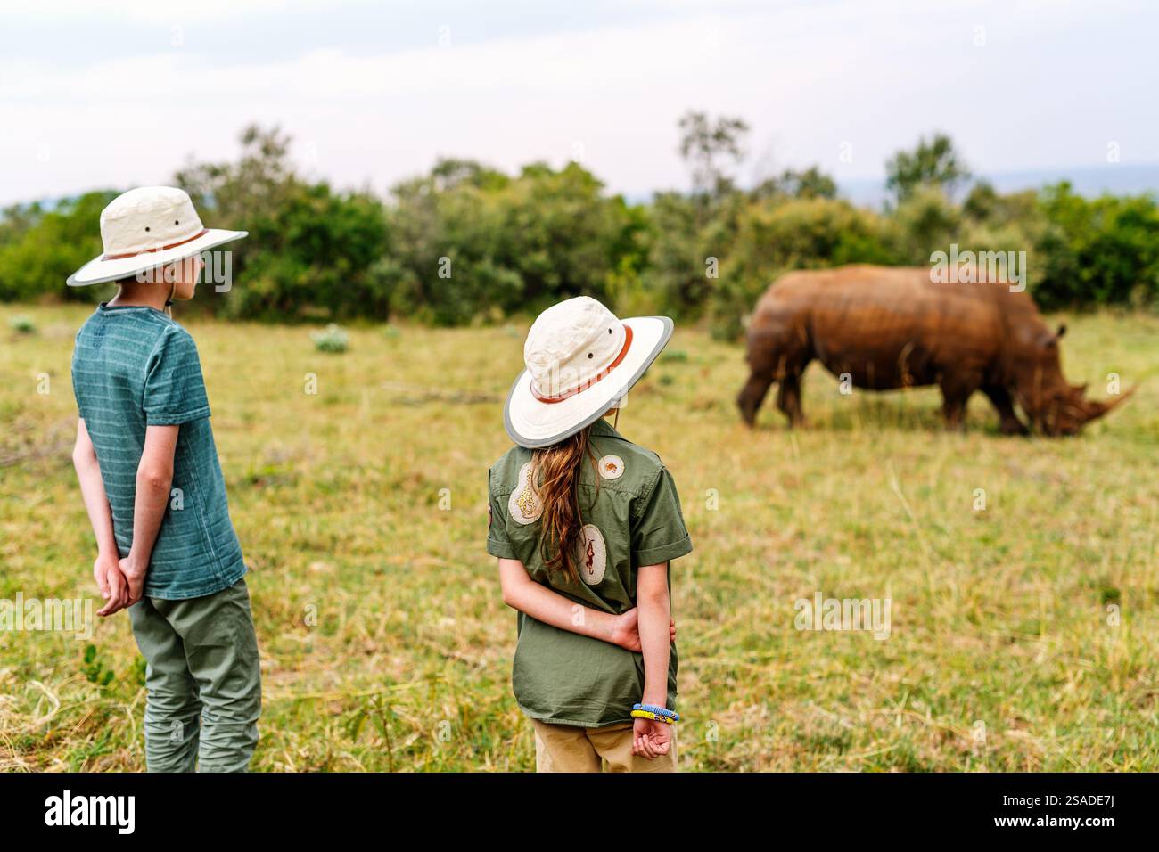 Vue arrière d'enfants sur safari à pied près de white rhino Banque D'Images