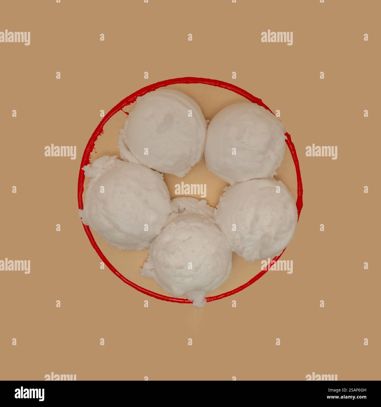 Des boules blanches de fausse glace dans un bol imaginaire à ligne rouge. Banque D'Images