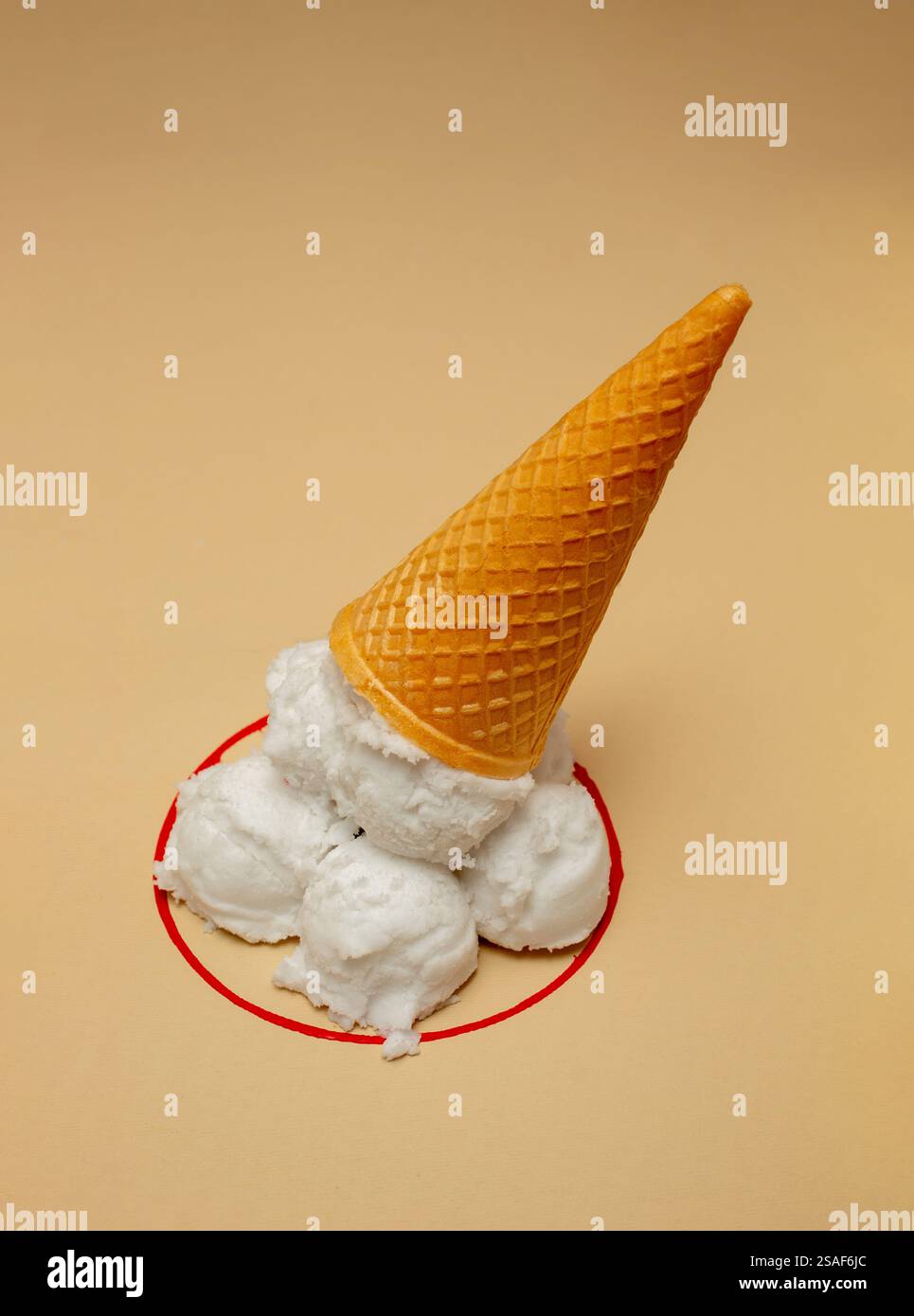 Des boules blanches de fausse glace dans un cône retourné dans un bol imaginaire de ligne rouge. Banque D'Images