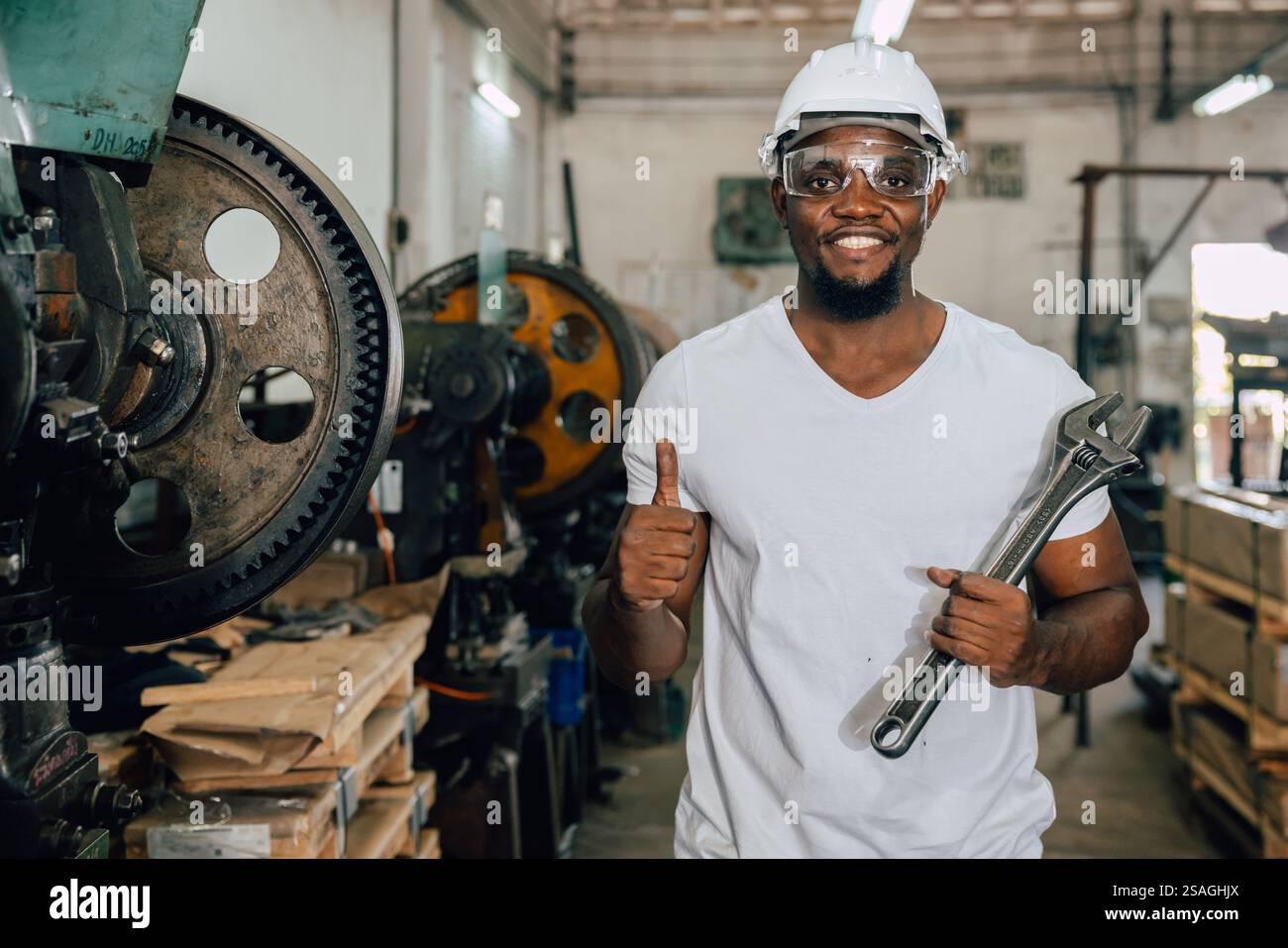 portrait travailleur noir africain heureux sourire poignée grand travail de service de clé dans l'atelier d'usine de métal Banque D'Images