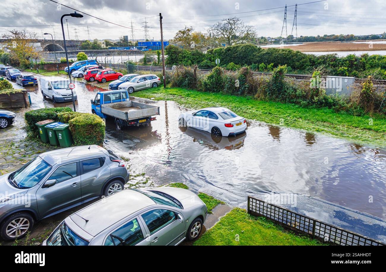 Une voiture BMW blanche en panne échouée sur une route inondée après de fortes pluies et une marée haute sur l'estuaire de la rivière Test à Redbridge, Southampton, Hants Banque D'Images