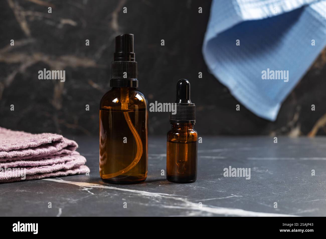 Ensemble de cosmétiques naturels. Bouteilles ambrées avec du liquide facial et une serviette en lin. Vue de face. Banque D'Images