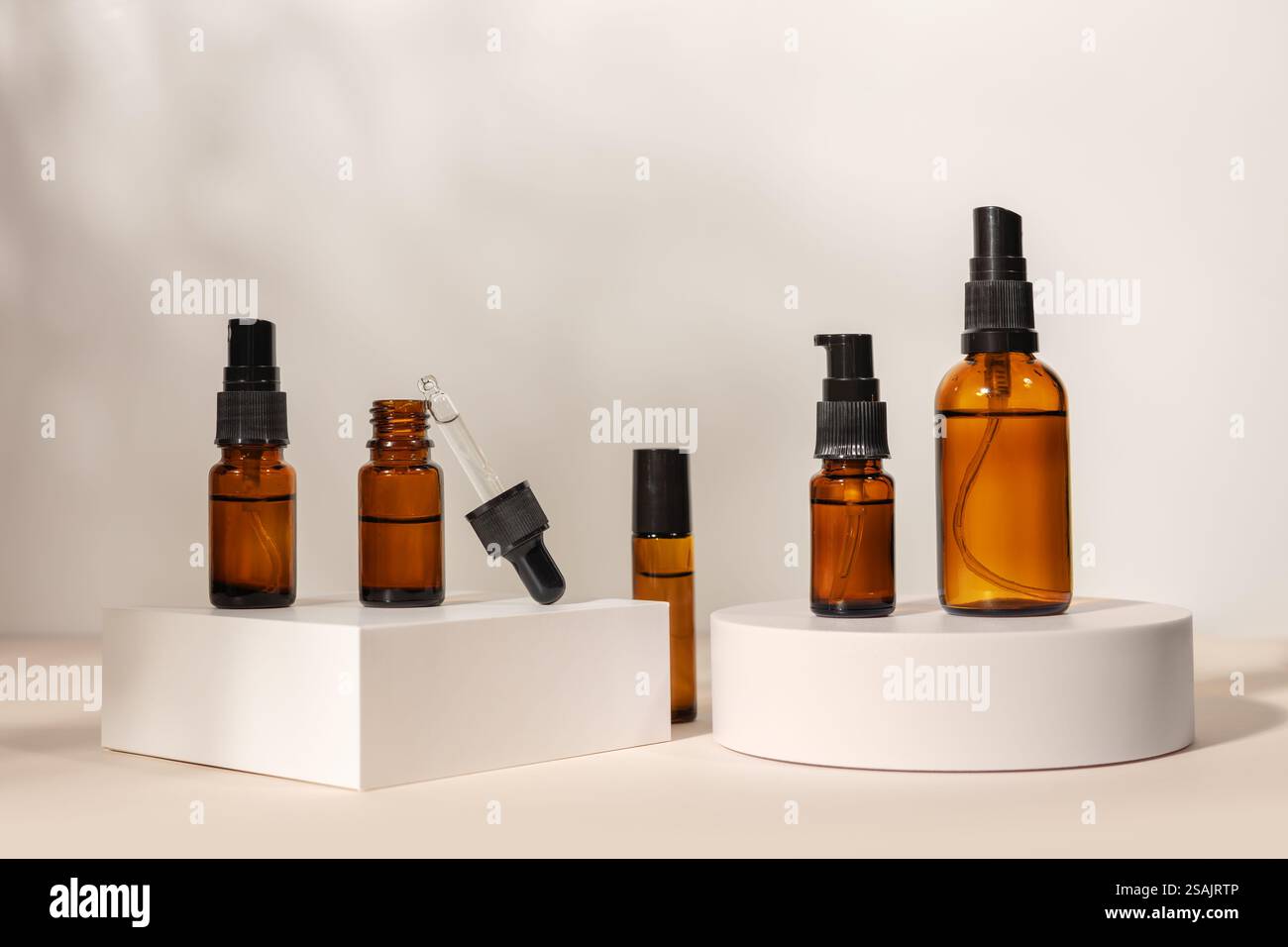 flacon en verre brun avec une pipette sur un podium sur un fond beige, concept cosmétique naturel. Banque D'Images