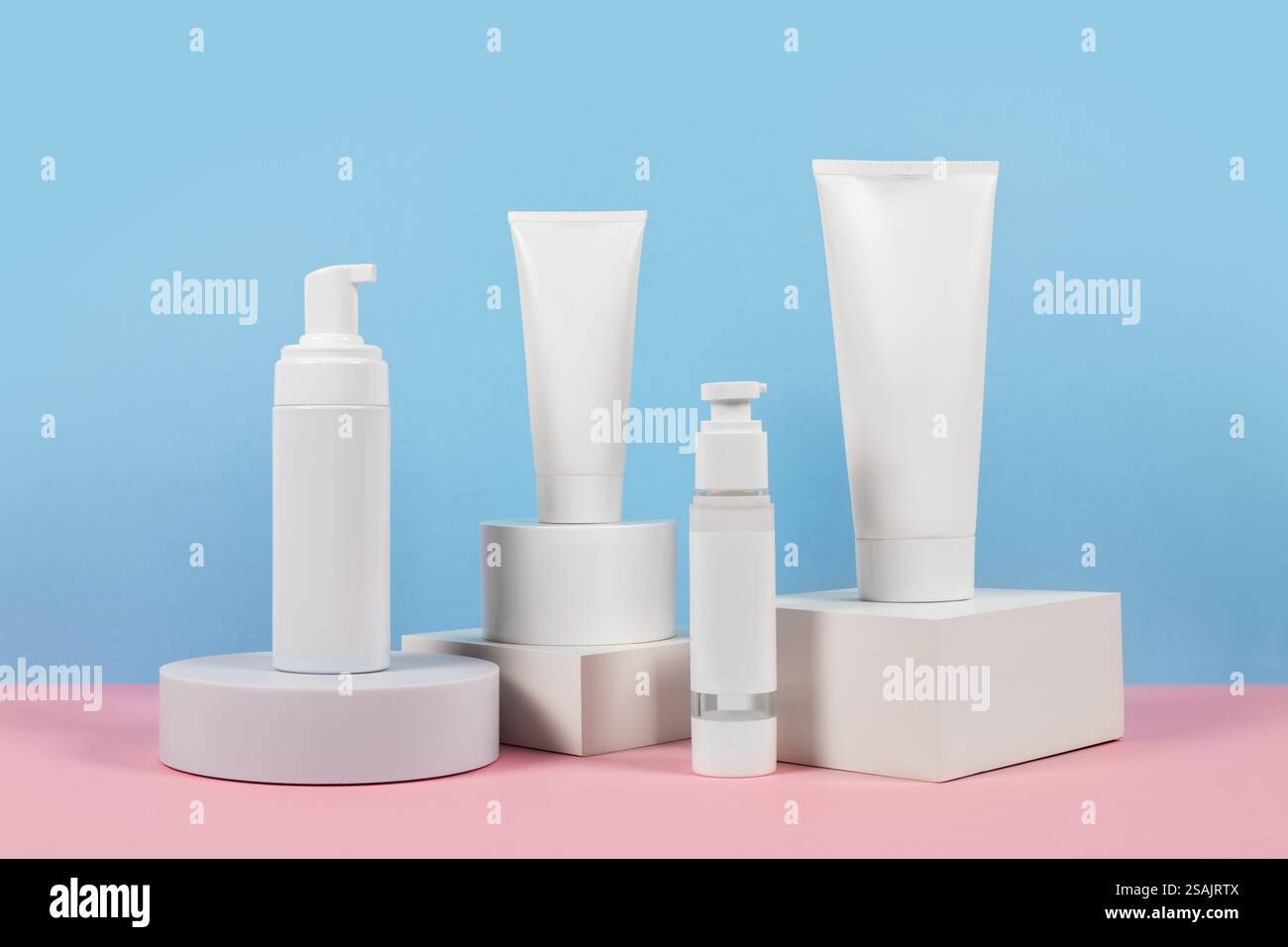 Beaux modèles cosmétiques pour les annonces, tubes de crème en plastique et bouteilles sur un fond bleu avec des podiums. Design esthétique pour un produit haut de gamme Banque D'Images