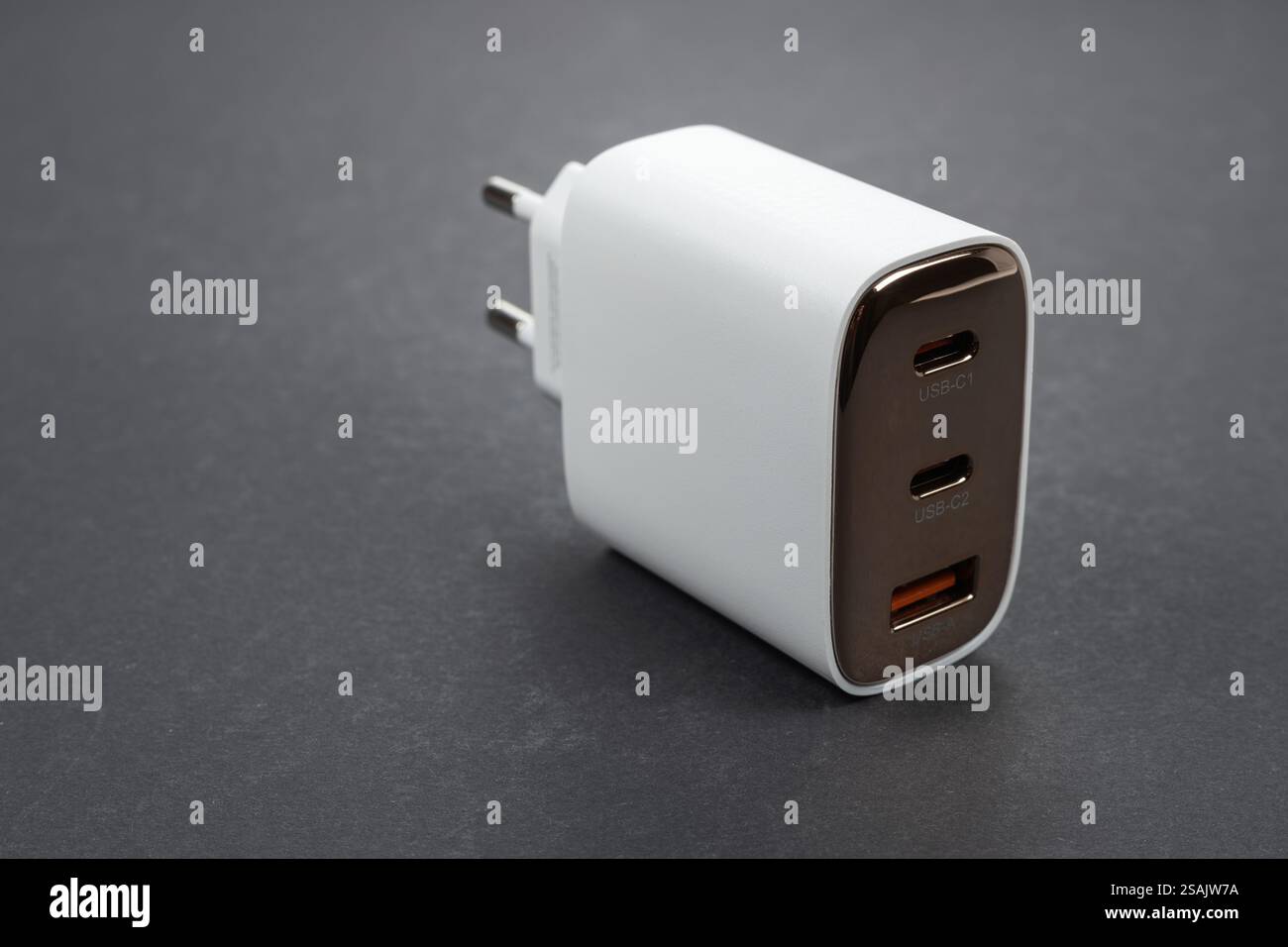 Chargeur de téléphone blanc sur fond gris. Chargeur de tension blanc pour téléphone et gadgets charge. Chargeur de smartphone. Banque D'Images