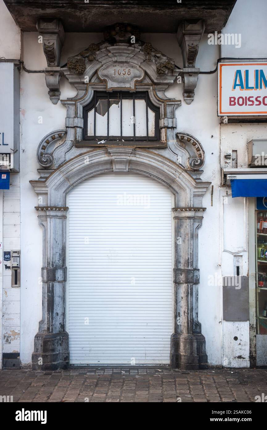 Porte baroque historique avec arche en pierre ornée et détails sculptés dans le centre de Bruxelles, Belgique, datée de 1658, montrant le patrimoine architectural urbain Banque D'Images