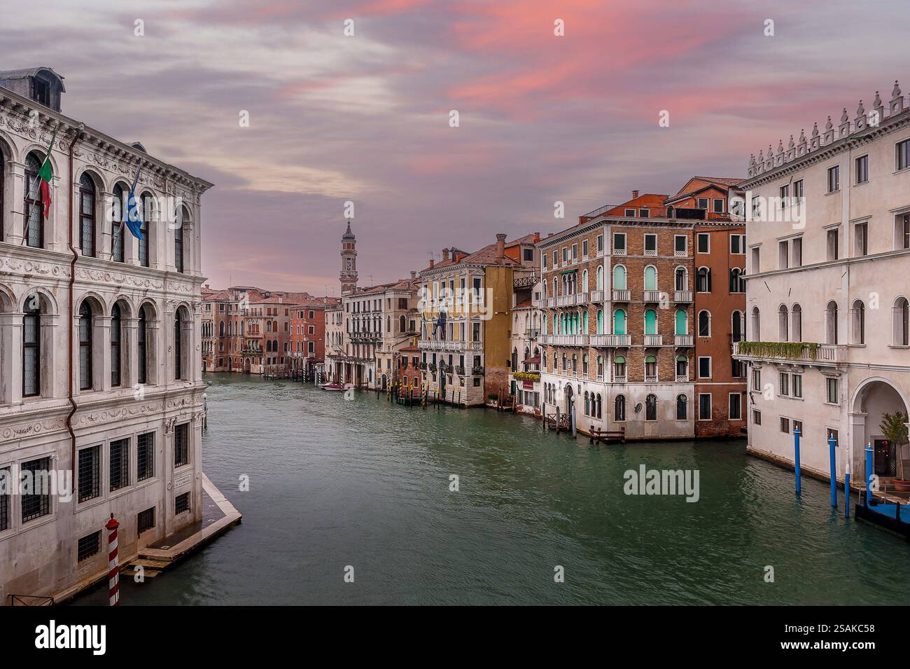 Venise Grand canal au crépuscule avec des bâtiments historiques, des lumières chaudes et des eaux calmes reflétant le coucher du soleil. Banque D'Images