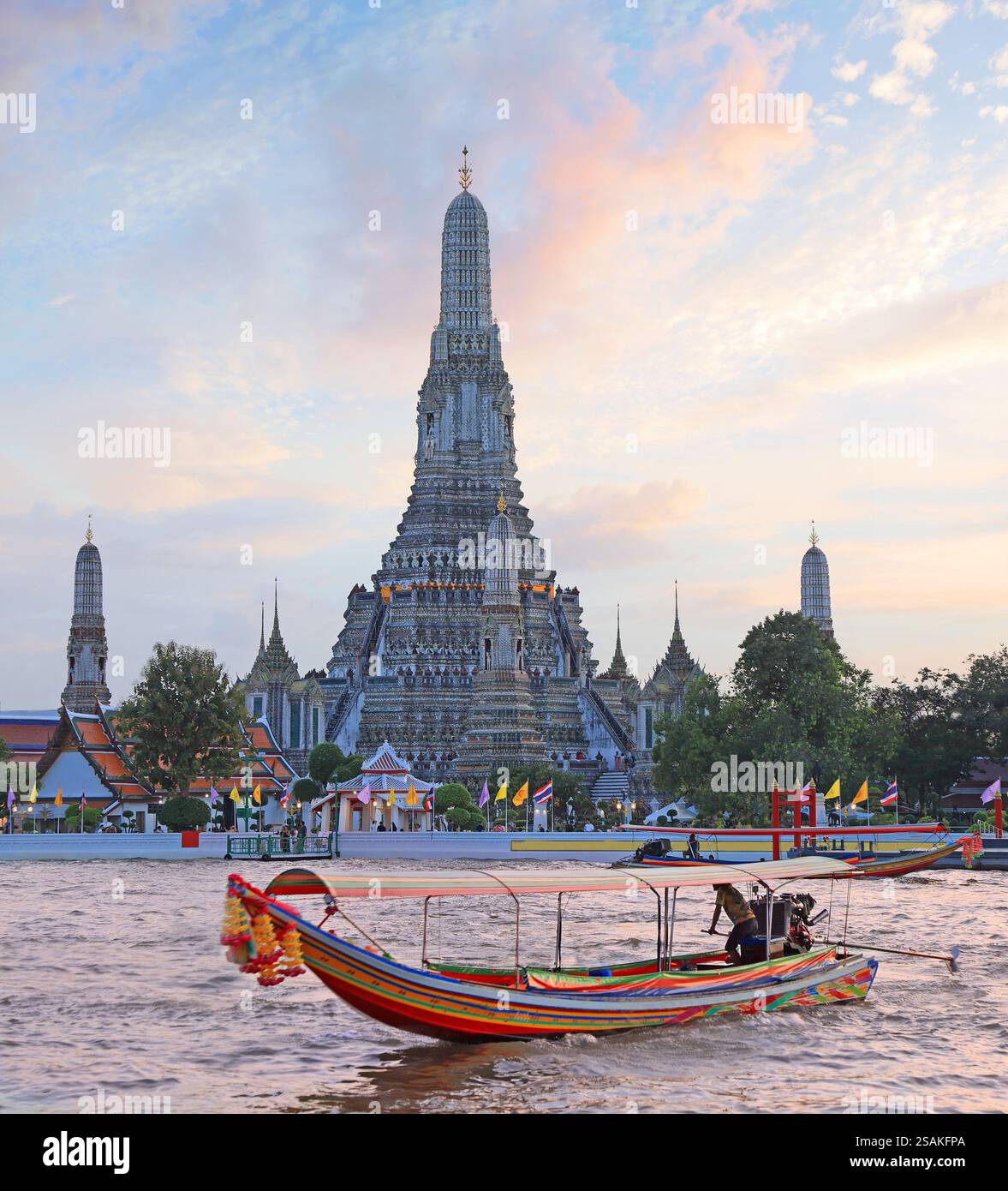 Temple Wat Arun au coucher du soleil avec bateau traditionnel sur la rivière au premier plan, Bangkok, Thaïlande Banque D'Images