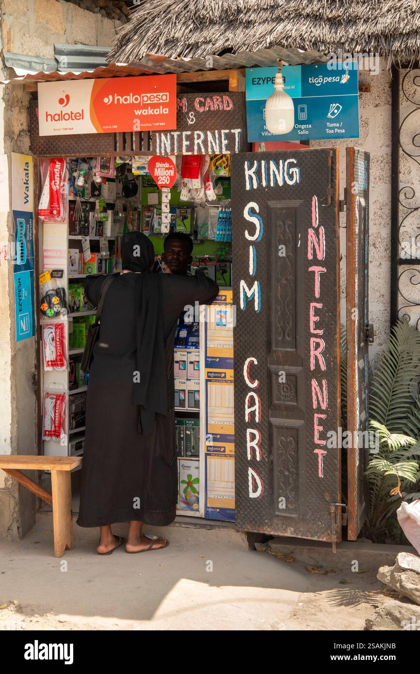 Afrique Tanzanie, Zanzibar, Côte est, Paje, Michavi Road, femme musulmane à la cabine de téléphone portable Banque D'Images