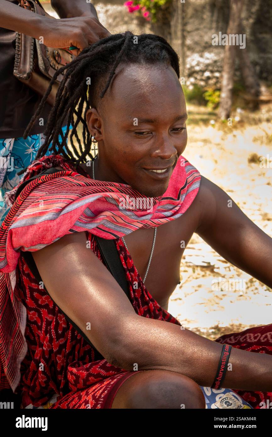 Afrique Tanzanie, Zanzibar, Côte est, Dongwe, homme Maasai ayant les cheveux tressés par un ami Banque D'Images Afrique Tanzanie, Zanzibar, Côte est, Dongwe, homme Maasai ayant les cheveux tressés par un ami Banque D'Images