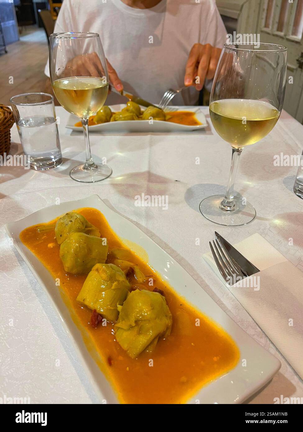 Manger des artichauts avec sauce aux légumes. Espagne. Banque D'Images