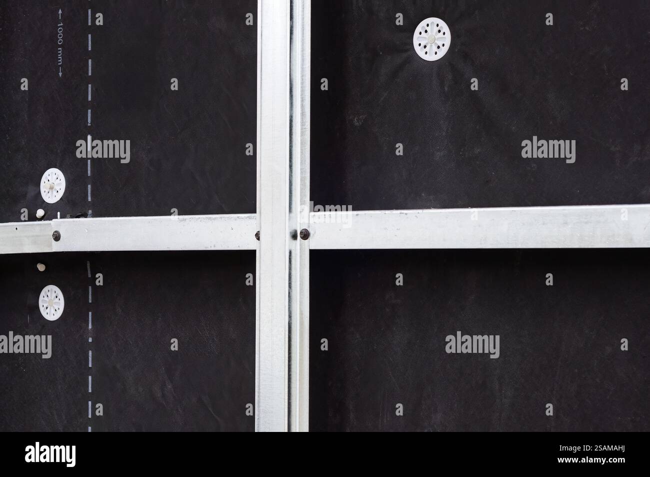 Plan détaillé de l'isolation de façade avec des profils et des vis, mettant en évidence le processus d'installation. Banque D'Images